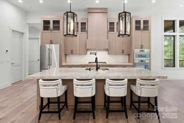 a kitchen with stainless steel appliances granite countertop a sink stove and refrigerator