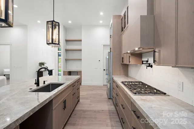 a kitchen with stainless steel appliances granite countertop a sink stove and refrigerator