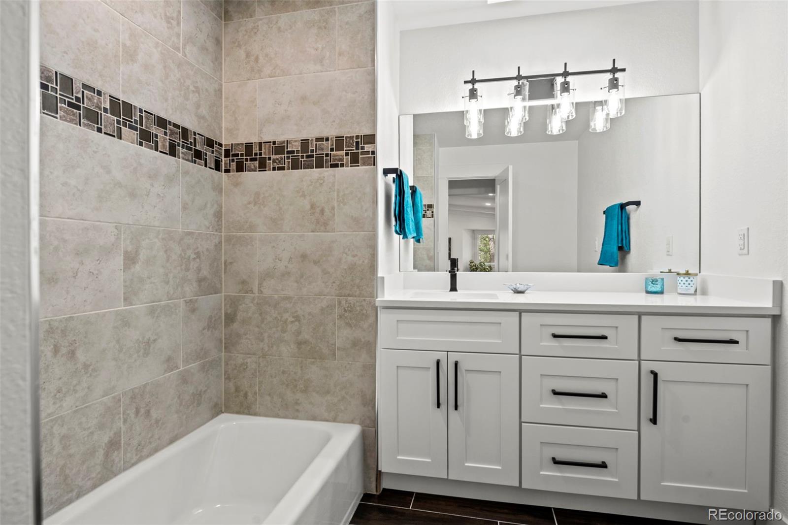 28877 Cedar Circle Evergreen, CO 80439 - Photo 18 of 30 a bathroom with a double vanity sink a mirror a bathtub and shower