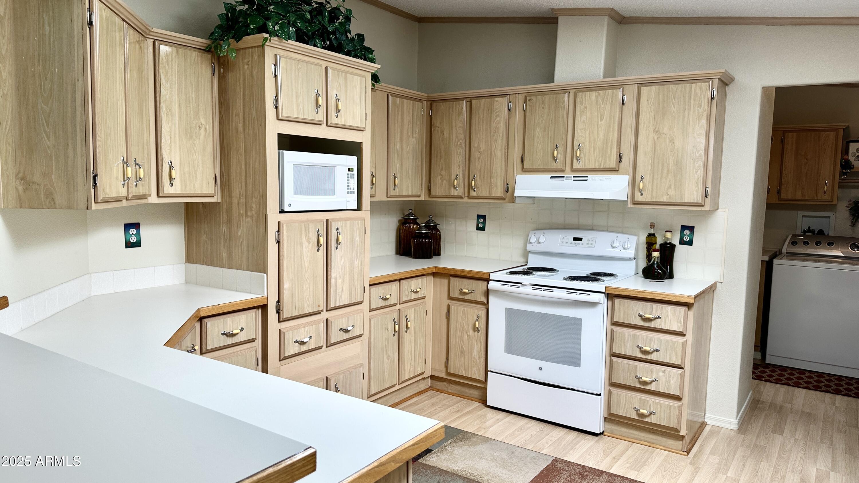 834 South Meridian Road, Unit 76 Apache Junction, AZ 85120 - Photo 34 of 50 a kitchen with stainless steel appliances granite countertop a stove a sink and a refrigerator