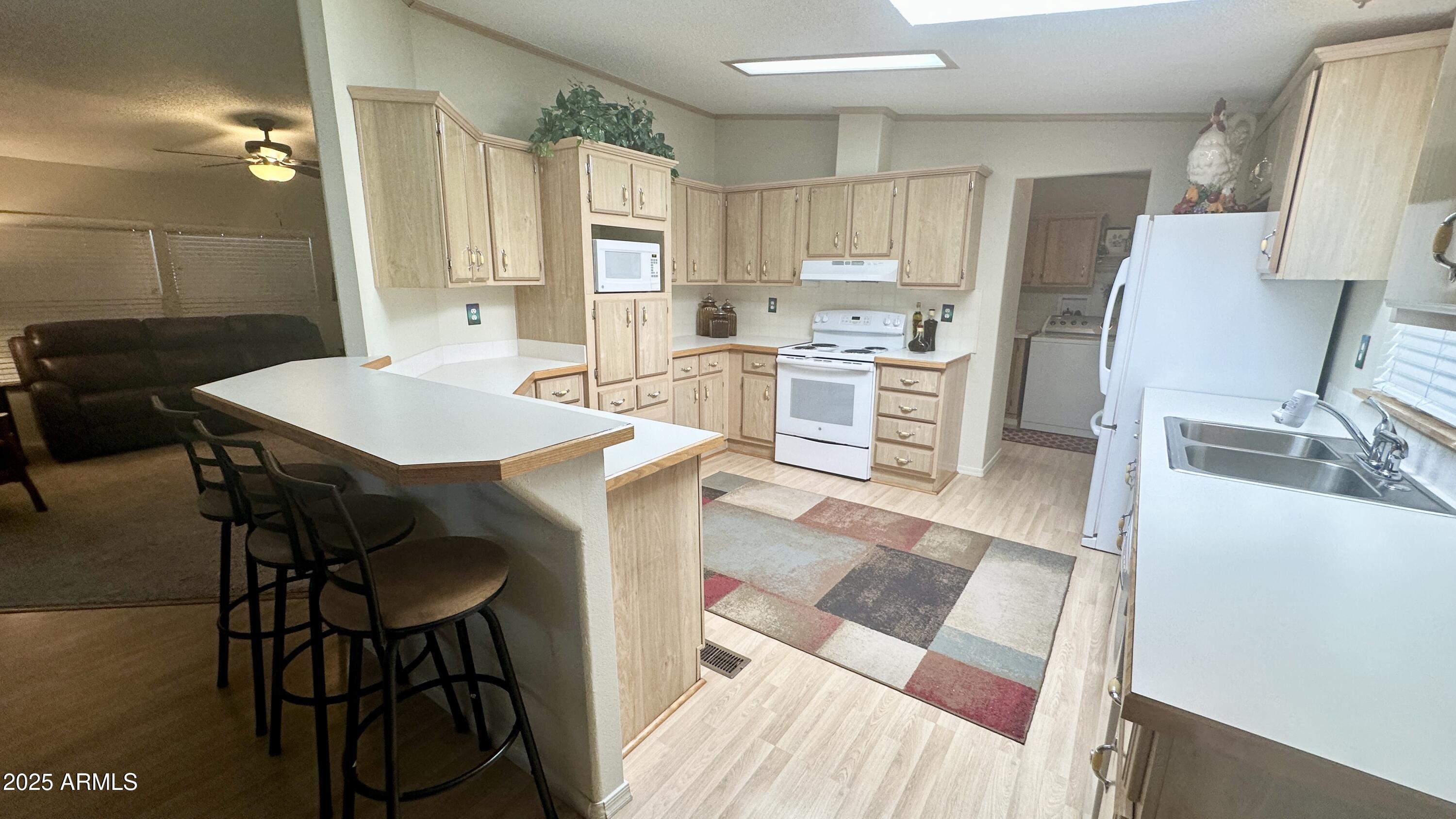 834 South Meridian Road, Unit 76 Apache Junction, AZ 85120 - Photo 36 of 50 a kitchen with a table chairs refrigerator and cabinets