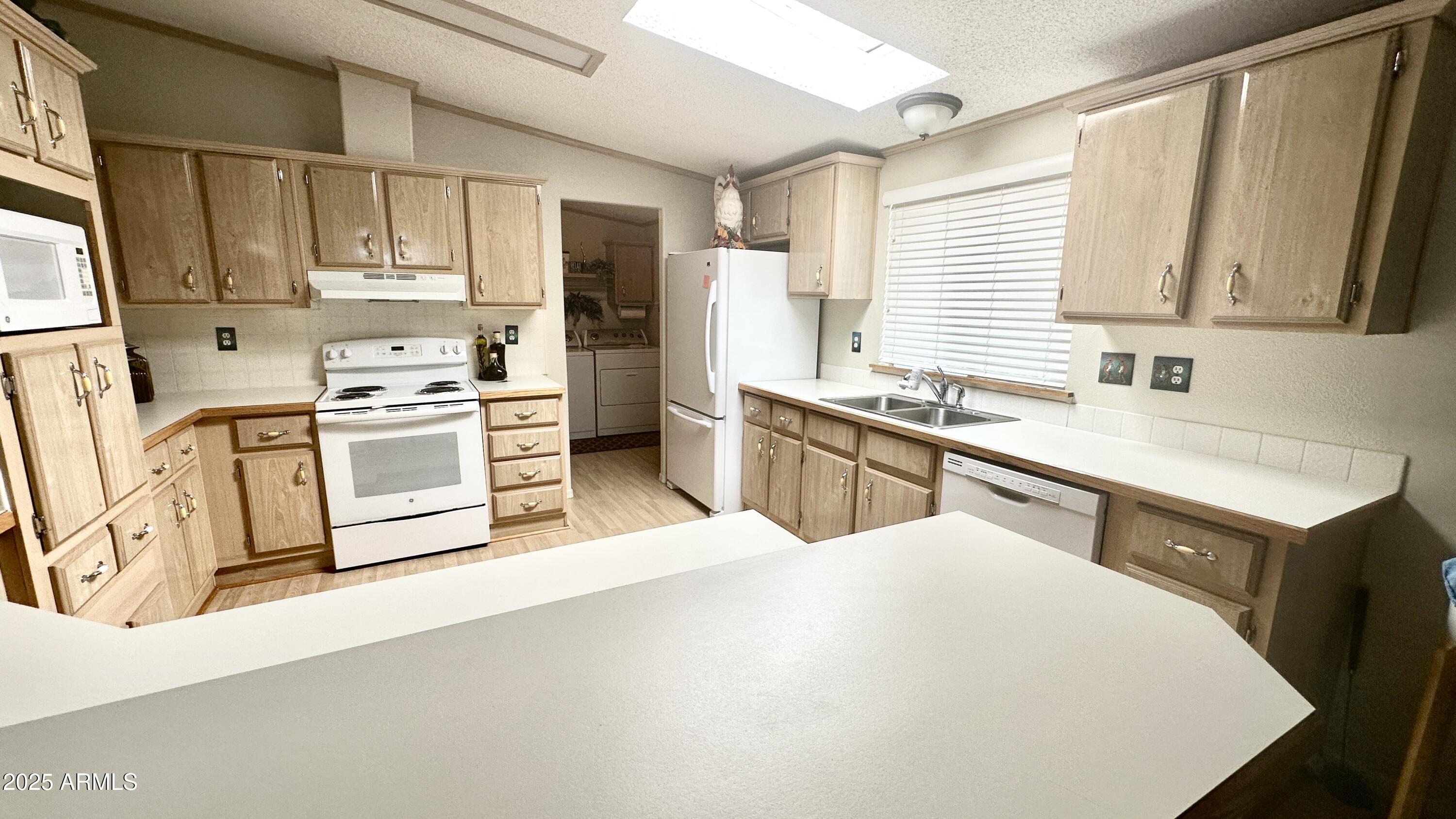 834 South Meridian Road, Unit 76 Apache Junction, AZ 85120 - Photo 37 of 50 a kitchen with stainless steel appliances a sink a stove a refrigerator cabinets and a window