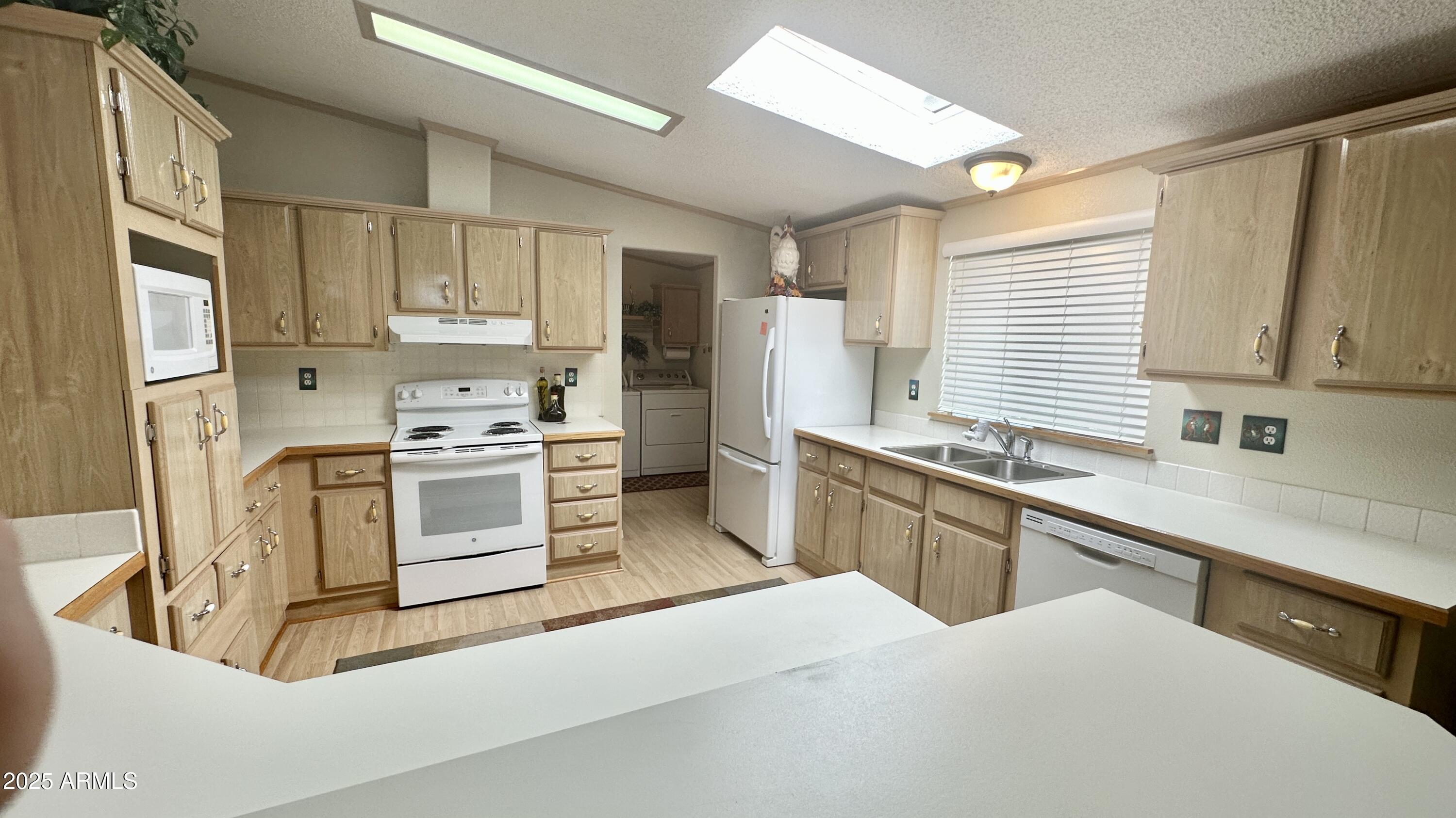 834 South Meridian Road, Unit 76 Apache Junction, AZ 85120 - Photo 39 of 50 a kitchen with stainless steel appliances white cabinets a sink a stove a refrigerator and cabinets