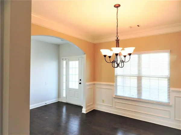 a view of a livingroom with wooden floor a ceiling fan and a fireplace
