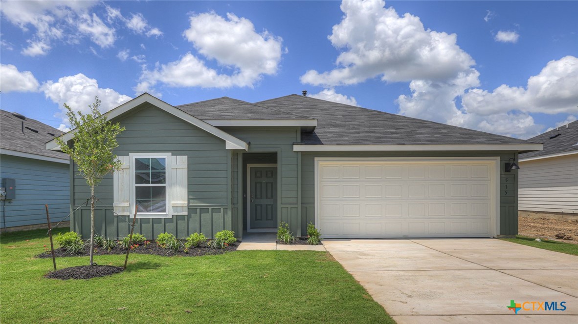 a front view of a house with a garden and yard