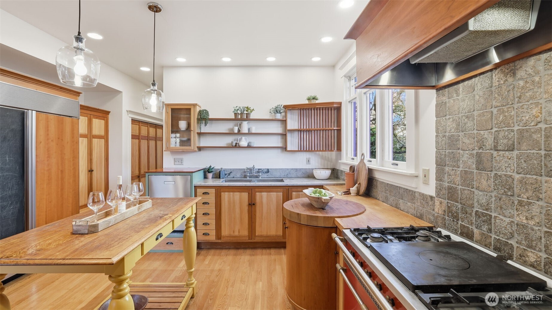 908 15th Avenue East Seattle, WA 98112 - Photo 13 of 37 a kitchen with stainless steel appliances a stove a sink dishwasher and a dining table with wooden floor