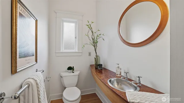 a bathroom with a granite countertop toilet sink and mirror