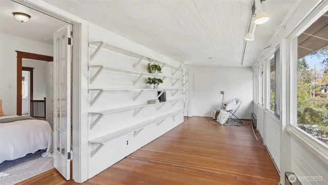 a view of a bedroom with wooden floor and windows