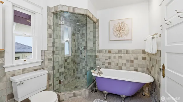 a bathroom with a bath tub a toilet and a shower