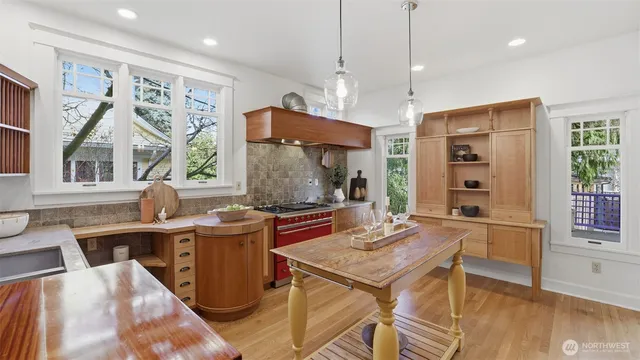 a kitchen with stainless steel appliances granite countertop a stove a sink dishwasher and a refrigerator with wooden floor