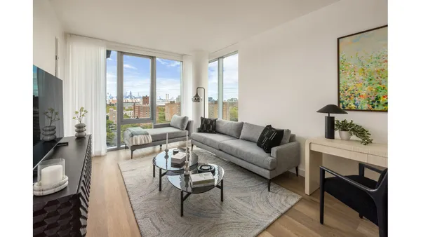 a living room with furniture and a floor to ceiling window