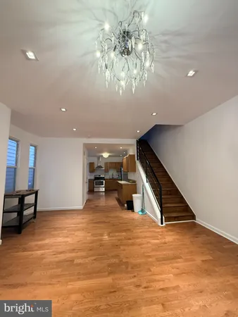 a view of an empty room with stairs and a ceiling fan