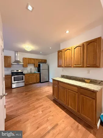 a large kitchen with stainless steel appliances kitchen island granite countertop a stove a sink and a microwave
