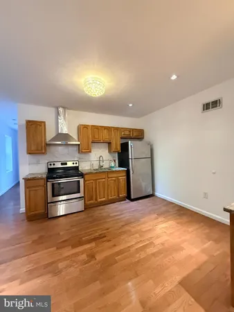 a kitchen with stainless steel appliances a stove a sink and a refrigerator