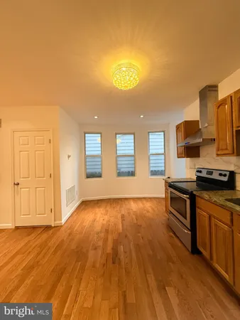 a kitchen with stainless steel appliances granite countertop a stove and a wooden floors