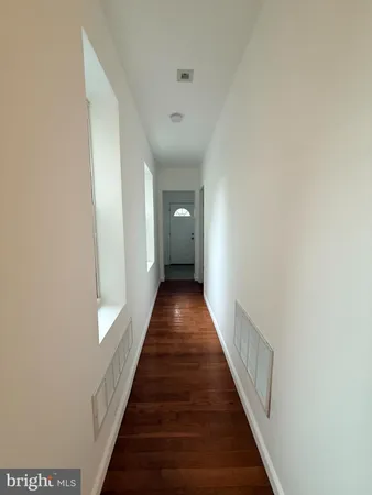 a view of a hallway with wooden floor