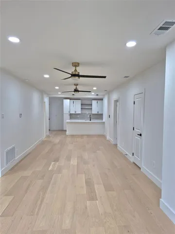 a view of empty room with wooden floor and windows