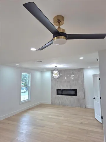 a view of a room with a ceiling fan and window