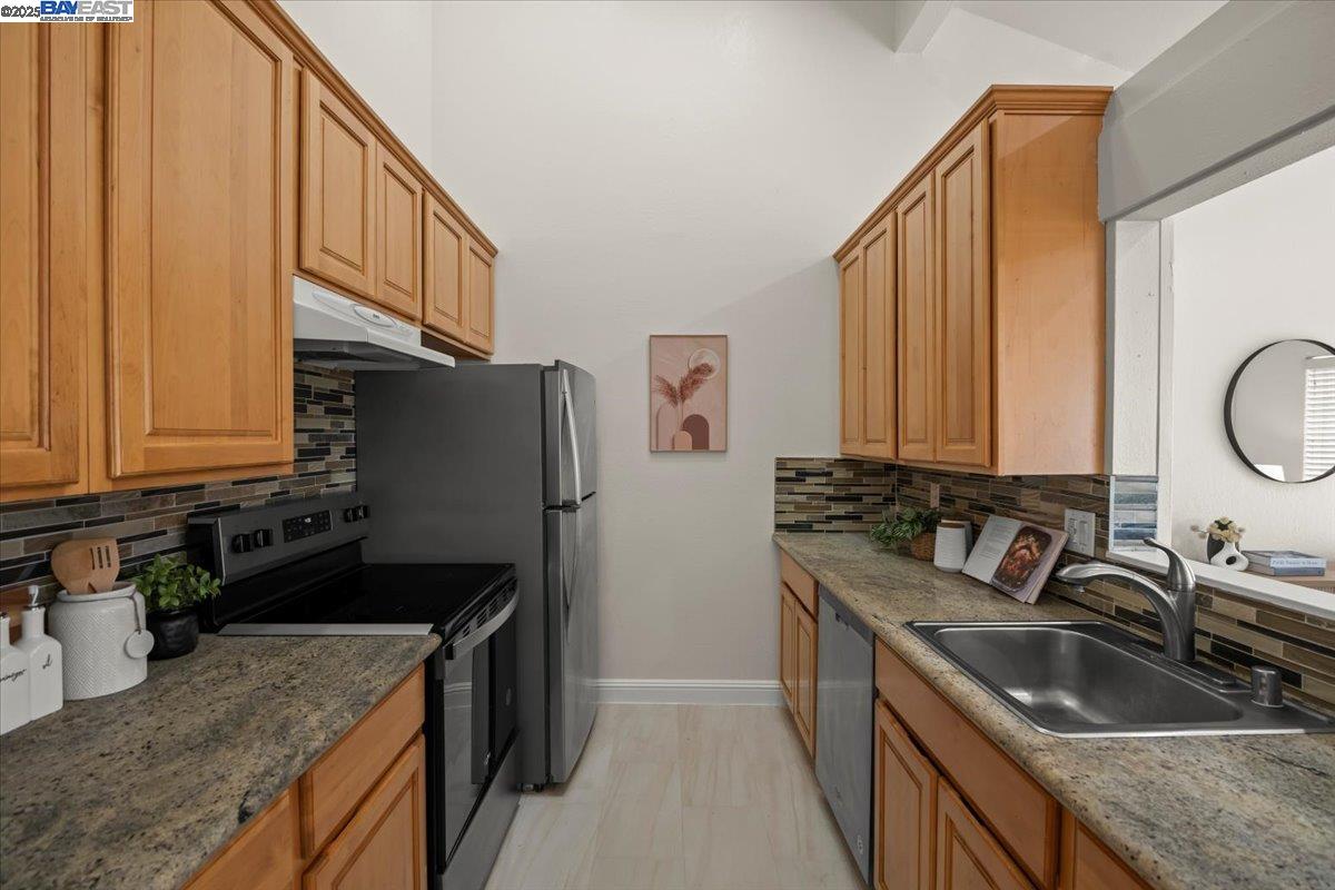 2253 Kalenda Common Fremont, CA 94539 - Photo 20 of 38 a kitchen with a sink stove top oven and cabinets