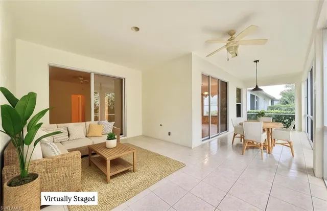 a living room with furniture potted plant and a large window