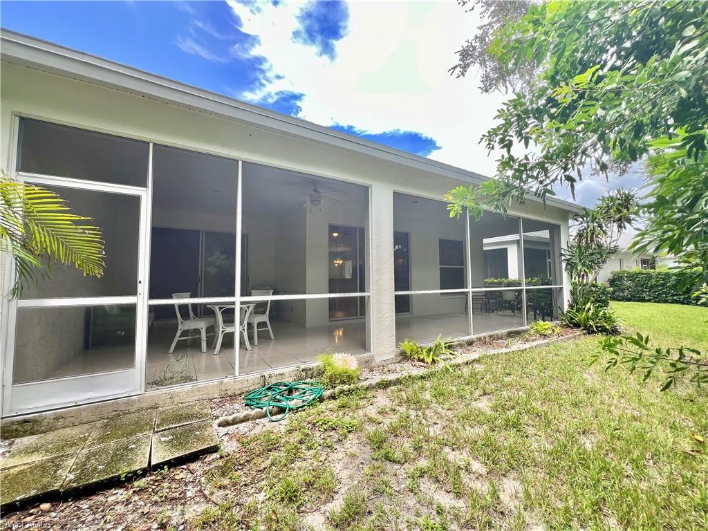 443 Crossfield Circle, Unit 74 Naples, FL 34104 - Photo 24 of 45 a view of a house with a large window and a yard with potted plants