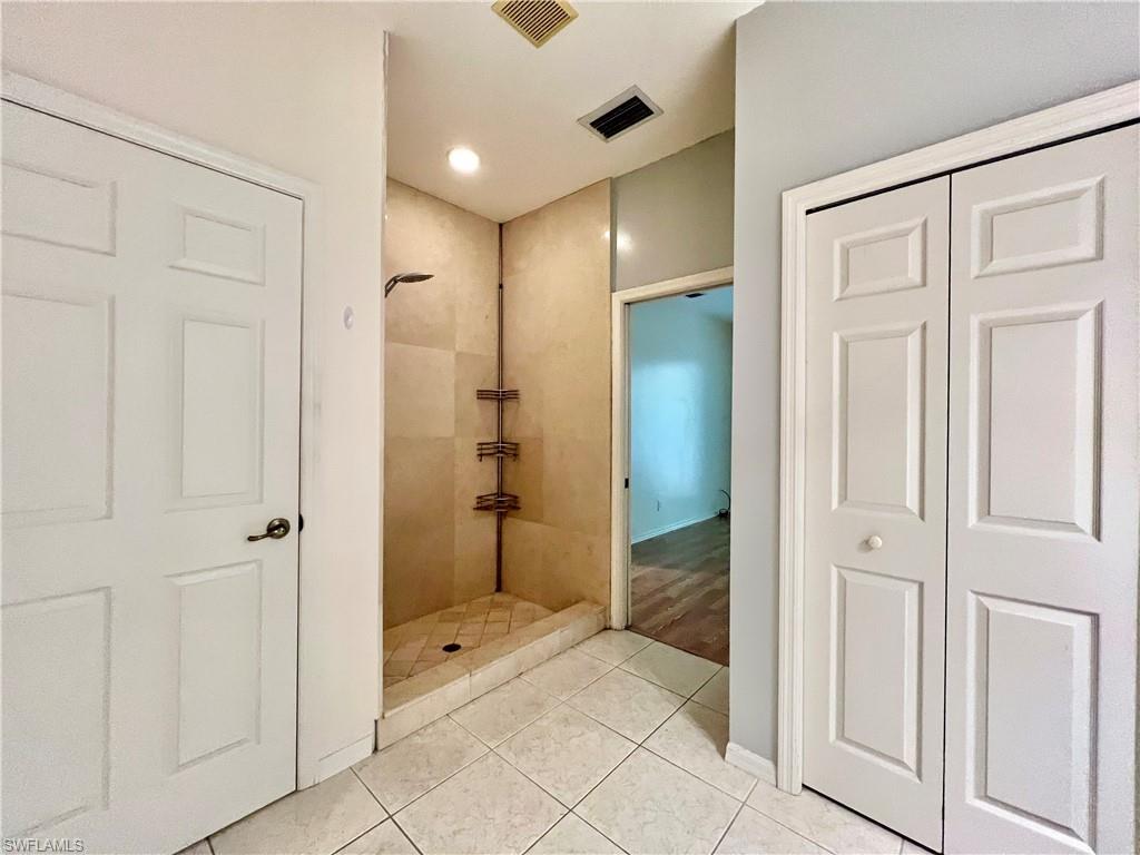 443 Crossfield Circle, Unit 74 Naples, FL 34104 - Photo 27 of 45 a bathroom with a shower and a glass door
