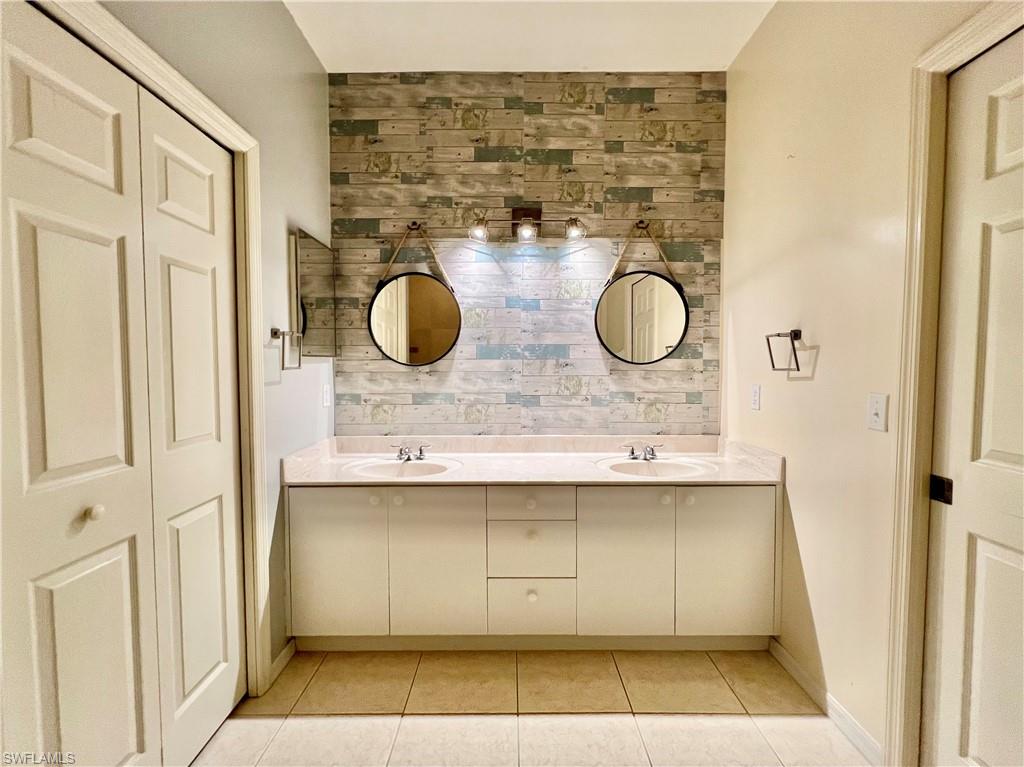 443 Crossfield Circle, Unit 74 Naples, FL 34104 - Photo 28 of 45 a bathroom with a sink and a mirror