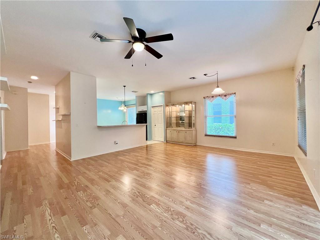 443 Crossfield Circle, Unit 74 Naples, FL 34104 - Photo 3 of 45 a view of an empty room with a window and wooden floor
