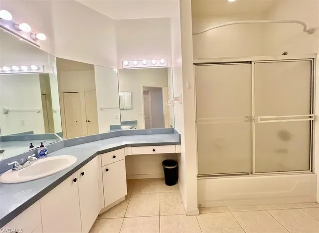 a spacious bathroom with a granite countertop sink a mirror and a bathtub