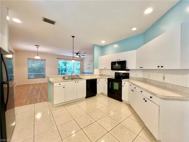 a kitchen with granite countertop a sink counter top space appliances and cabinets