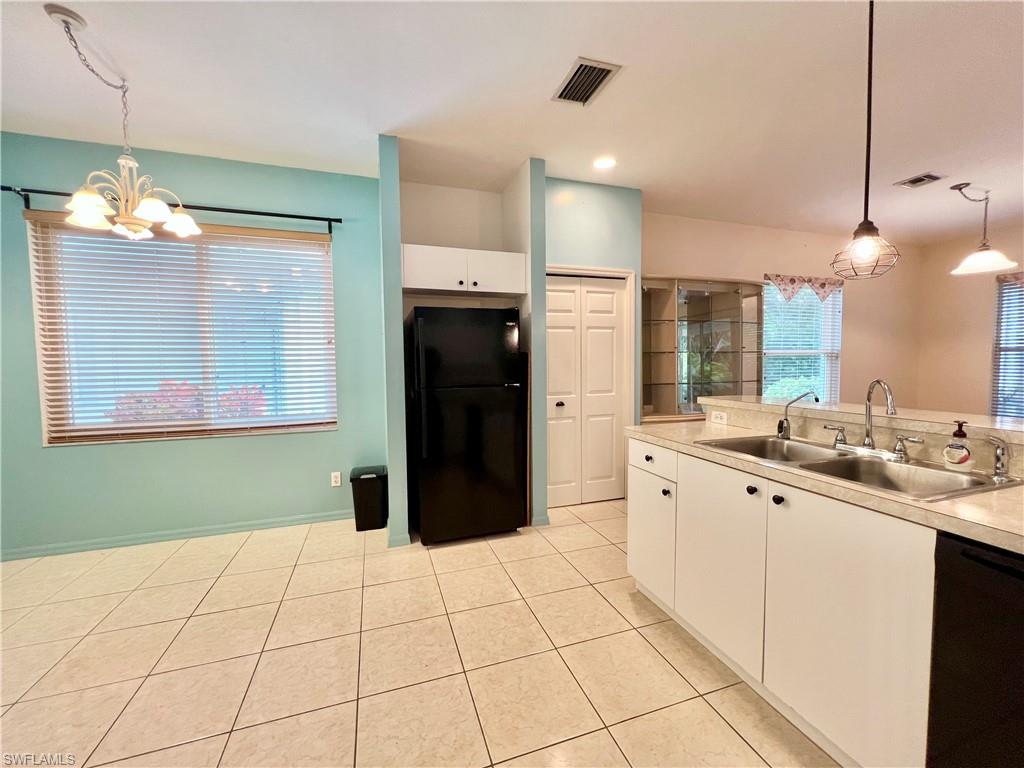 443 Crossfield Circle, Unit 74 Naples, FL 34104 - Photo 7 of 45 a kitchen with stainless steel appliances kitchen island granite countertop a refrigerator a sink and a wooden floors