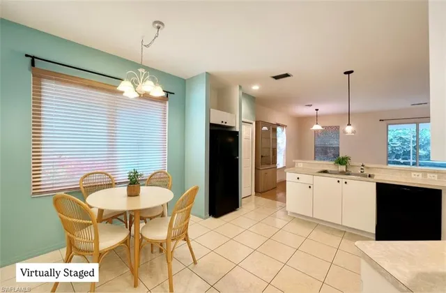 a kitchen with a dining table chairs and white cabinets