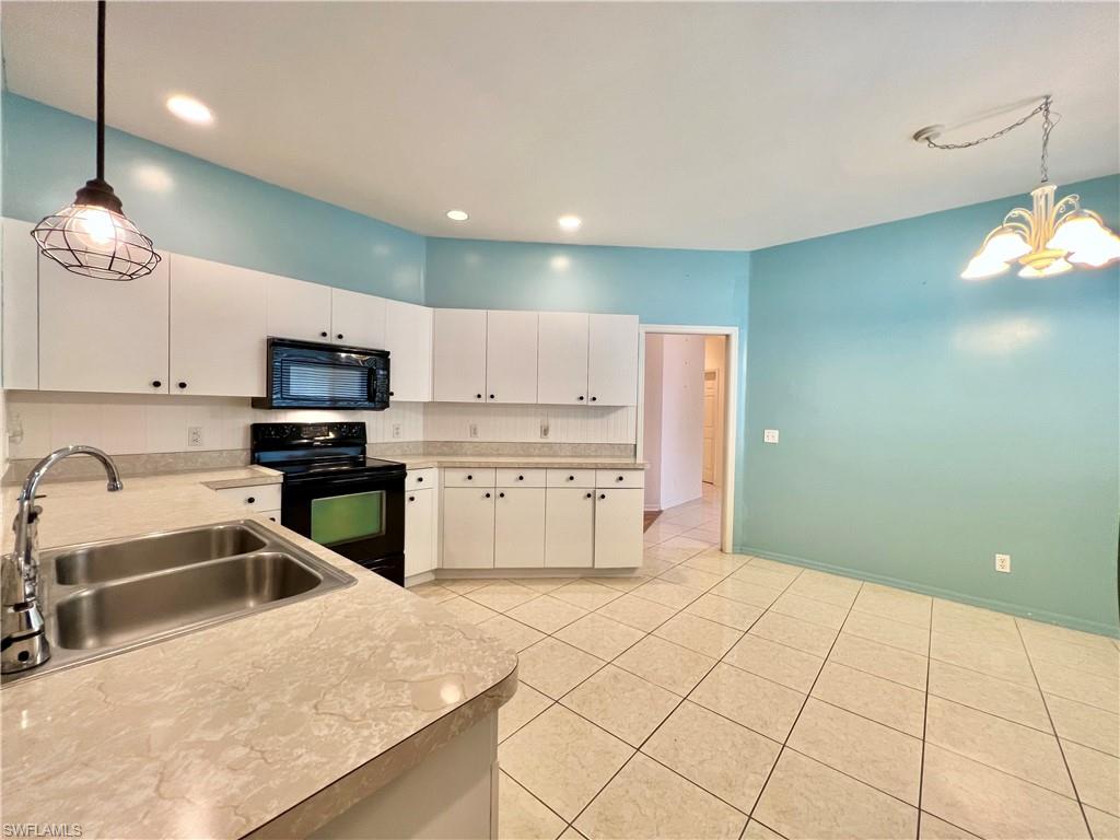 443 Crossfield Circle, Unit 74 Naples, FL 34104 - Photo 10 of 45 a kitchen with granite countertop a sink a counter top space appliances and cabinets