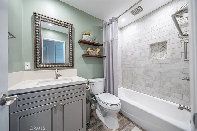 a bathroom with a sink a toilet a mirror a vanity and bathtub