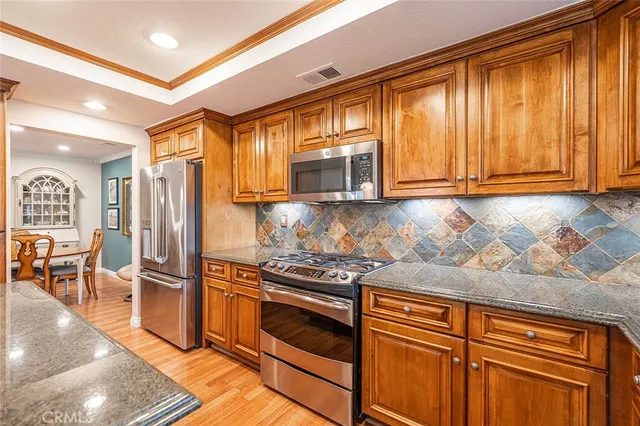 a kitchen with granite countertop stainless steel appliances and wooden cabinets