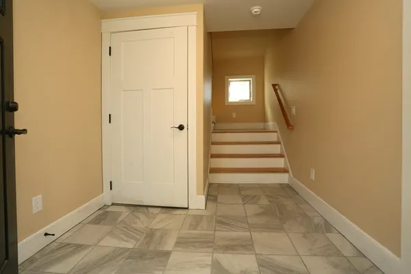 a view of a hallway with stairs and a door