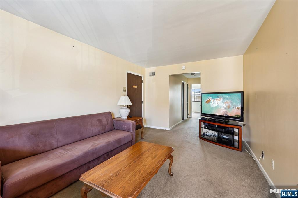 825 Riverside Avenue, Unit 207 Lyndhurst, NJ 07071 - Photo 4 of 18 a living room with furniture and a flat screen tv