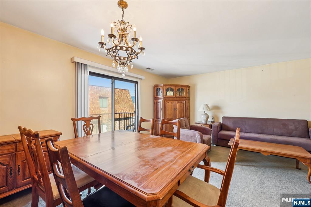 825 Riverside Avenue, Unit 207 Lyndhurst, NJ 07071 - Photo 7 of 18 a dining room with furniture a rug and a chandelier