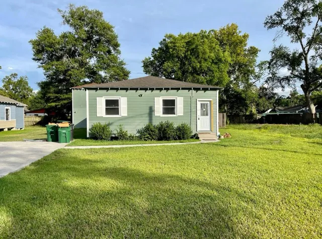 a front view of house with yard and trees around