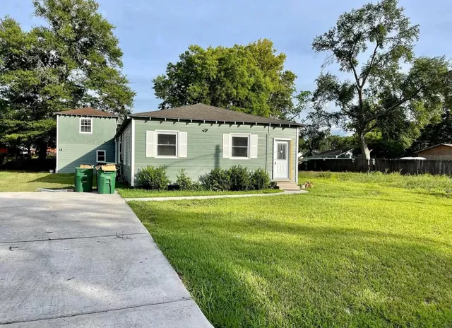a front view of a house with yard and green space
