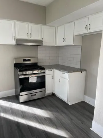 a kitchen with granite countertop white cabinets and white appliances