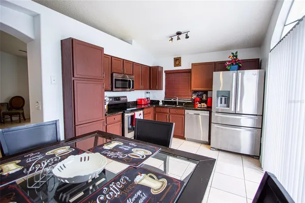 a kitchen with granite countertop a refrigerator stove and microwave