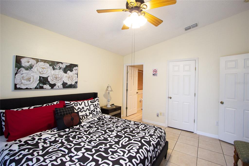 1832 Wimbledon Street Kissimmee, FL 34743 - Photo 18 of 39 a bedroom with a bed and a painting on the wall