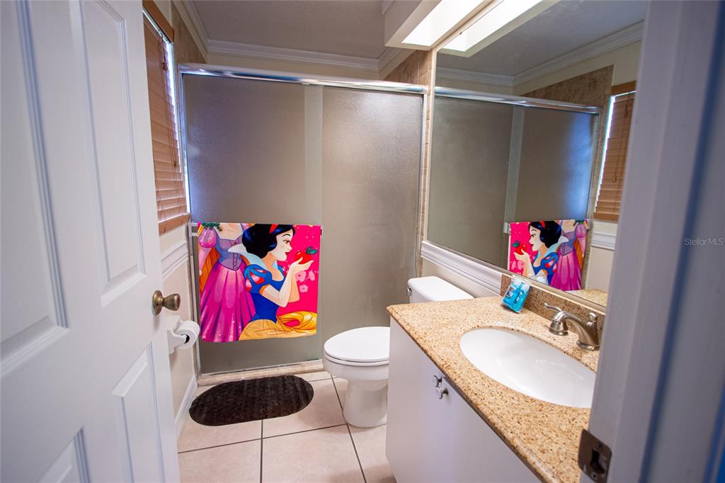 1832 Wimbledon Street Kissimmee, FL 34743 - Photo 19 of 39 a bathroom with a sink vanity mirror and toilet