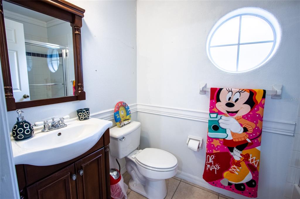 1832 Wimbledon Street Kissimmee, FL 34743 - Photo 26 of 39 a bathroom with a sink mirror and toilet