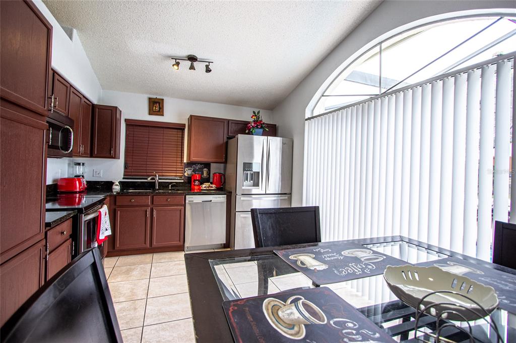 1832 Wimbledon Street Kissimmee, FL 34743 - Photo 10 of 39 a kitchen with kitchen island granite countertop a sink appliances and cabinets
