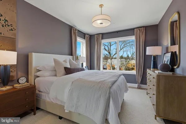 a bedroom with a bed and a flat tv screen on dresser
