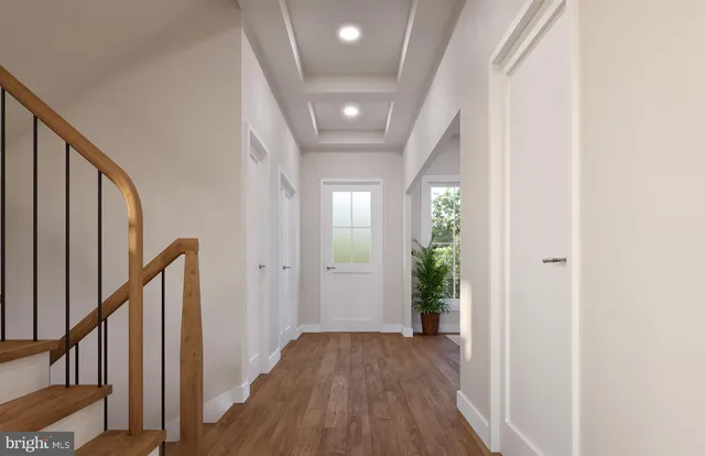 a view of a hallway with wooden floor and stairs
