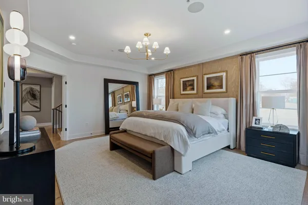 a spacious bedroom with a bed and a chandelier