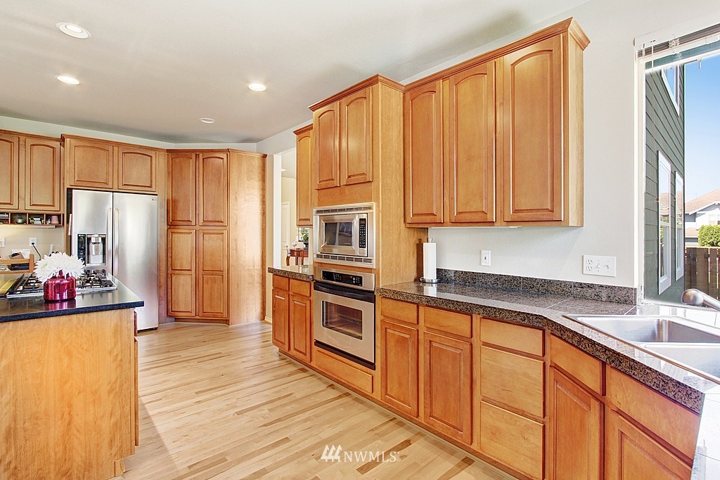 27712 Maple Ridge Way Southeast Maple Valley, WA 98038 - Photo 13 of 36 a kitchen with stainless steel appliances a refrigerator and a sink